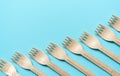 Wooden forks in a row on a blue background. minimalism