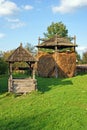 Wooden fountain and haycock roof Royalty Free Stock Photo