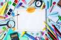 Wooden frame, alarm clock, different stationery and colorful supplies on blue background. Back to school concept. Top view