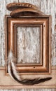 Wooden frame, burlap ribbon and feathers on the old wood Royalty Free Stock Photo