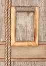 Wooden frame on the burlap with sacking ribbon and rope