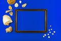 Wooden frame compoisition with summer seashell on a blue background, copy space, top view