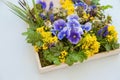Wooden frame with flowers, pansies and other yellow and purple wildflowers, floral picture