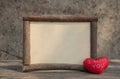 Wooden frame with red heart on the wooden table