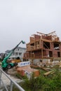 Wooden frame of a house under construction with a crane lifting supplies