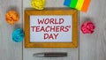 Wooden frame with inscription `World Teachers` Day` on beautiful wooden table, colored paper, metalic pen. Concept