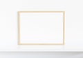 Wooden frame leaning on white shelve in bright interior mockup 3D rendering