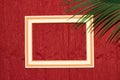 wooden frame in the middle of a red background in the corner of a palm leaf, creative art design, copy space