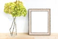 Wooden frame mockup with green flowers. Poster product design styled mock-up