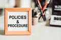 Wooden frame with office background with text POLICIES&PROCEDURE