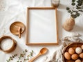 A wooden frame sits on a white tablecloth, surrounded by kitchenware and cooking ingredients