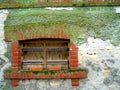 Wooden frame window on an old brick building covered with moss Royalty Free Stock Photo