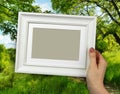 Wooden frame in woman hands. background of the creek in the forest