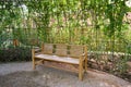 Wooden furniture chairs in rose garden, Covered with trees Royalty Free Stock Photo