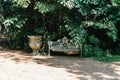 Wooden furniture in the garden against the backdrop of a fire on the patio. Among the branches of the bush stands a wooden table Royalty Free Stock Photo