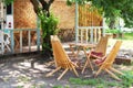 Wooden furniture set for Picnic in garden. Empty sun loungers and table on veranda of house in forest. outdoor furniture for leisu Royalty Free Stock Photo