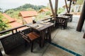 Wooden furniture on veranda cafe on background red roofs bungalow Royalty Free Stock Photo