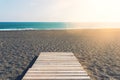 Wooden gangplank on beach against sea and blue sky