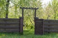 Wooden garden fence with open door and green grass on a spring day Royalty Free Stock Photo