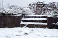 Wooden garden stair covered by snow