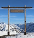Wooden gate with a blank sign on top of a snow covered mountain Royalty Free Stock Photo