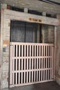 The wooden gate is closed to a very old freight elevator in an old warehouse building. Royalty Free Stock Photo