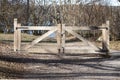 Wooden gate closing off dirt road Royalty Free Stock Photo