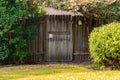 Wooden gate door in the garden with green trees and bushes Royalty Free Stock Photo