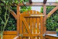 Wooden gate and fence on the back of the home garden. The gate is closed with a padlock. Royalty Free Stock Photo