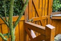 Wooden gate and fence on the back of the home garden. The gate is closed with a padlock. Royalty Free Stock Photo