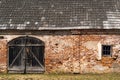 Wooden gate and small window of old building made by red bricks Royalty Free Stock Photo