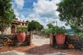 Wooden gate, stone fence, plants in tubs with a building