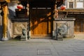 Wooden gate with stone lions of old-fashioned building in sunny