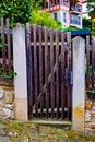 Wooden gate with stone wall behind it and house in the background in Germany. Royalty Free Stock Photo