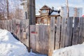 Wooden gate to the house behind a fence