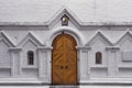 Wooden gate and two arched windows on a white brick wall. Entrance to the old christian church Royalty Free Stock Photo