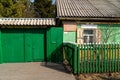 Wooden gates and a gate to the house-museum of the writer V.P. Astafiev with a memorial plaque at the entrance on a sunny spring