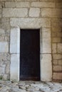 The gates of an old medieval castle or fortress, covered with strips of iron. The gate has a closed wicket with a handle Royalty Free Stock Photo