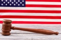 Wooden gavel on blurred American flag background.