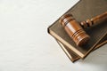 Wooden gavel and books on light table Royalty Free Stock Photo