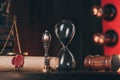 Wooden gavel, hourglass and antique stamp with last will on wooden table.