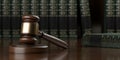 Wooden gavel, judges hammer or mallet on dark wood table with books in the background, law, legal or court symbol or concept, Royalty Free Stock Photo