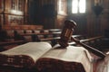 Wooden gavel sits on top of an open law book in a courtroom, symbolizing legal authority and justice