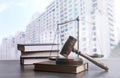 Wooden gavel, scales of justice and books on table against cityscape Royalty Free Stock Photo