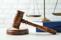 Wooden gavel, scales of justice and books on table against brick wall, closeup. Law Royalty Free Stock Photo