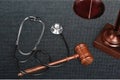 Wooden gavel and stethoscope on dark background