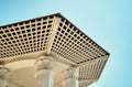 Wooden gazebo with carved columns and lattice hemming