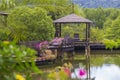 Wooden gazebo with sun loungers for relaxing on a terrace with flowers next to a lake on the tropical island of Thailand