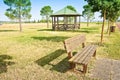 Wooden gazebos and picnic table with wooden bench in a public park with trees and shaded areas Royalty Free Stock Photo