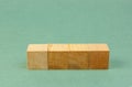 wooden geometric cube on a green background